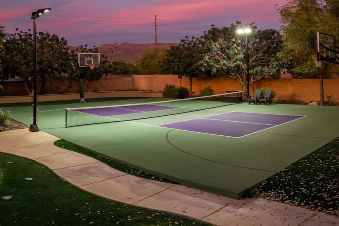 Multi-sport court with basketball hoops and tennis area under dramatic sunset skies, offering active recreation in peaceful mountain-view setting.