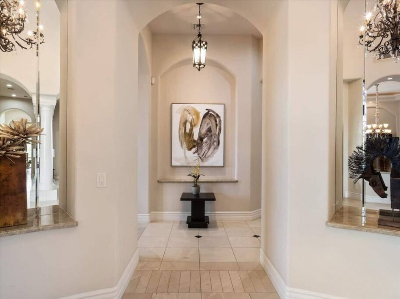 A welcoming archway leads you into an elegant foyer, where warm lighting and contemporary art create an inviting first impression that sets the tone for your stay.