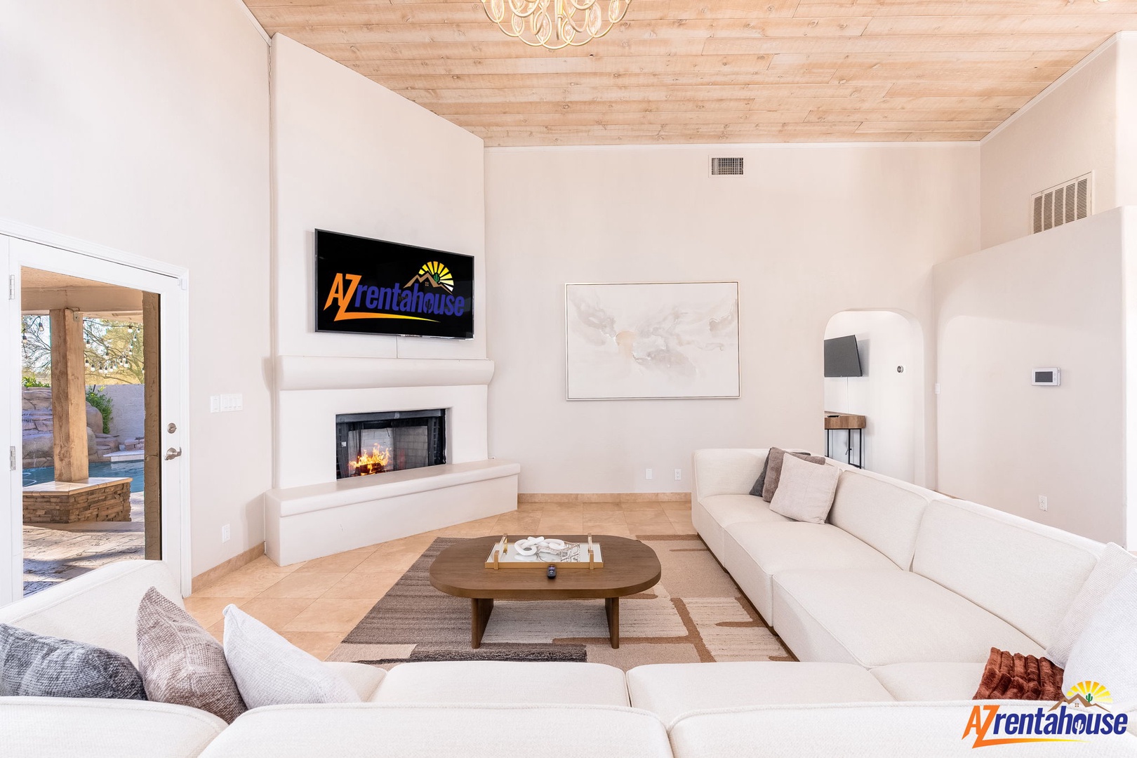 Sink into plush sofas beneath warm wood ceilings, gather by the cozy fireplace, and unwind in your inviting living space.