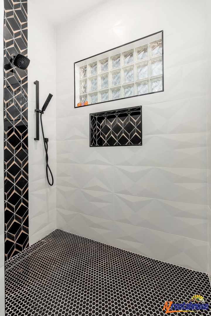 Step into your sleek walk-in shower featuring striking black geometric tiles and modern fixtures for a luxurious start to your day.