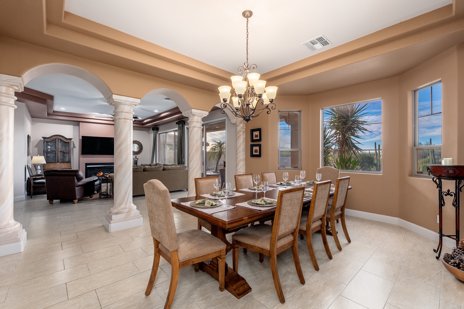 Gather around this elegant dining table for memorable meals together, with natural light pouring through the windows and archways leading to cozy living spaces beyond.