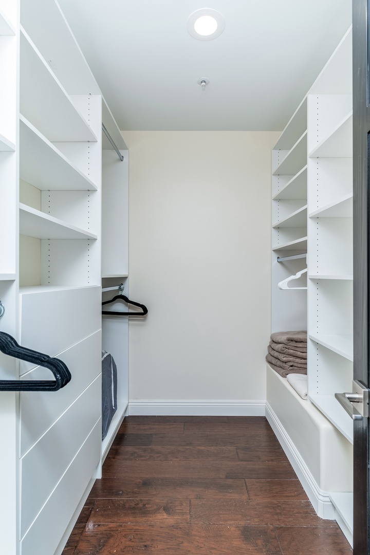 Your own spacious walk-in closet features custom shelving and hanging rods with ample room to organize everything you need for your stay.