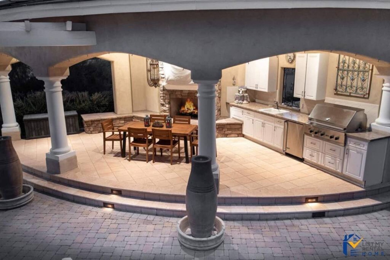 Your outdoor kitchen dreams come alive under elegant columns, where you'll grill, dine, and gather by the fireplace's warm glow.