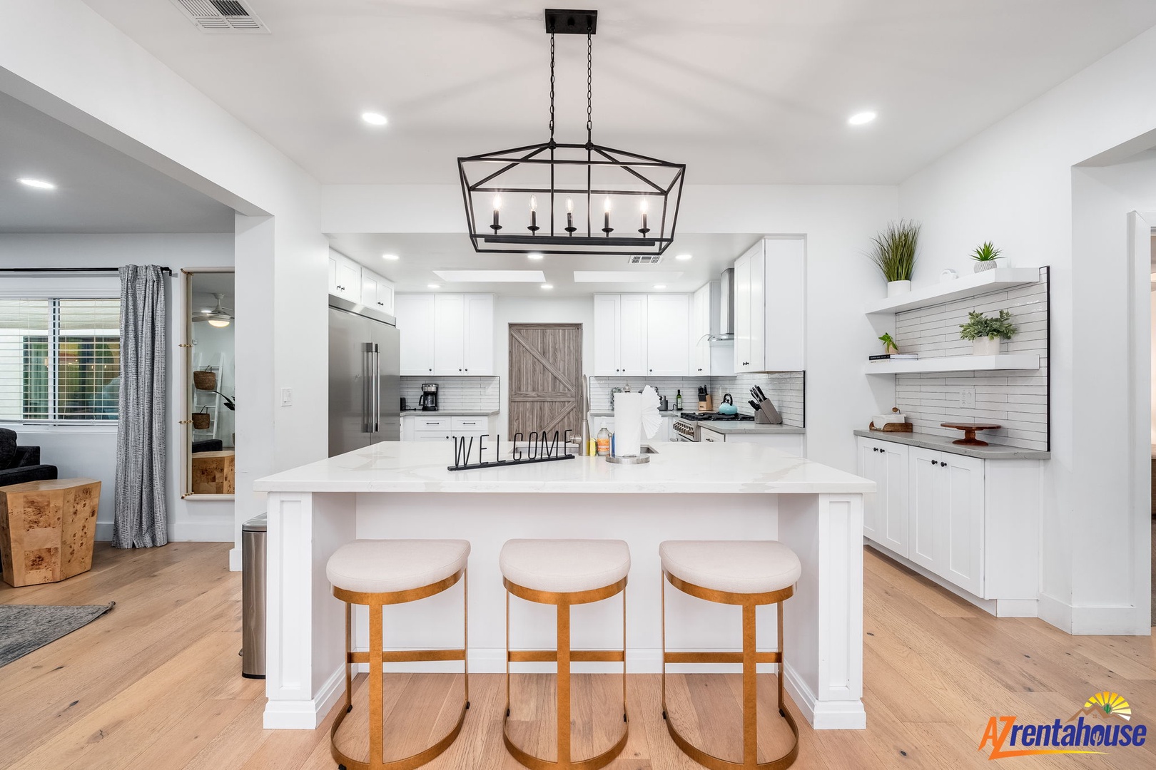 Step into this stunning modern kitchen where white cabinets, quartz countertops, and warm wood floors create your perfect cooking sanctuary.