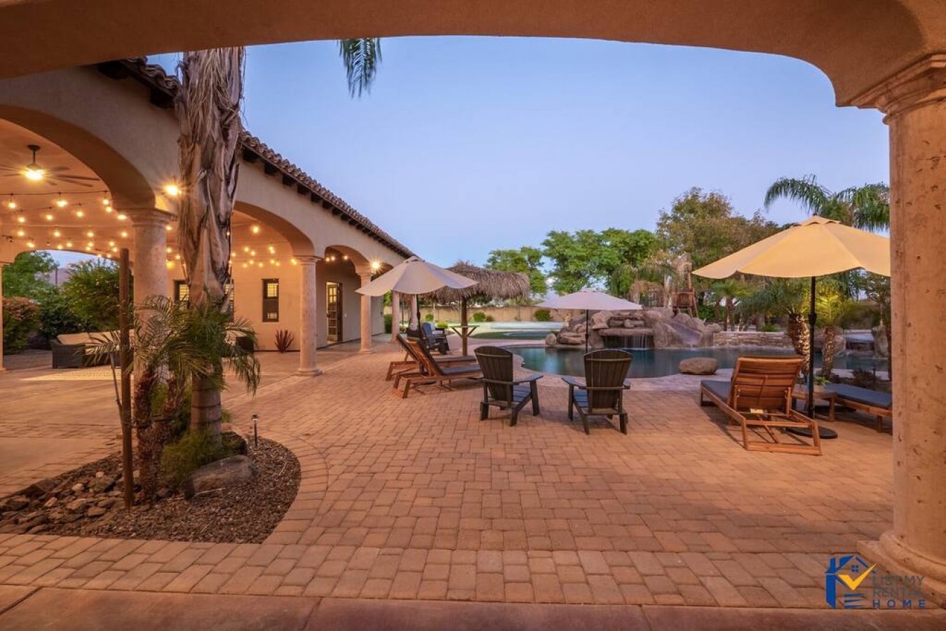 Step into your private oasis where twinkling lights create magic above comfortable poolside seating, perfect for evening relaxation.