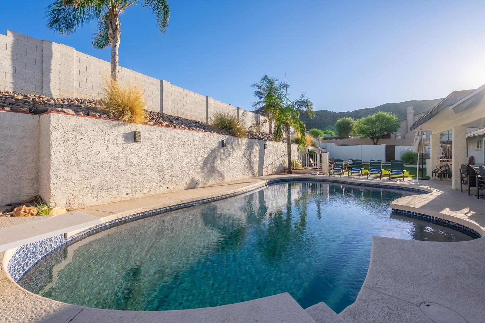 Dive into your private oasis, where sparkling turquoise waters await beneath swaying palms and mountain views—your personal retreat for sun-soaked relaxation and poolside bliss.