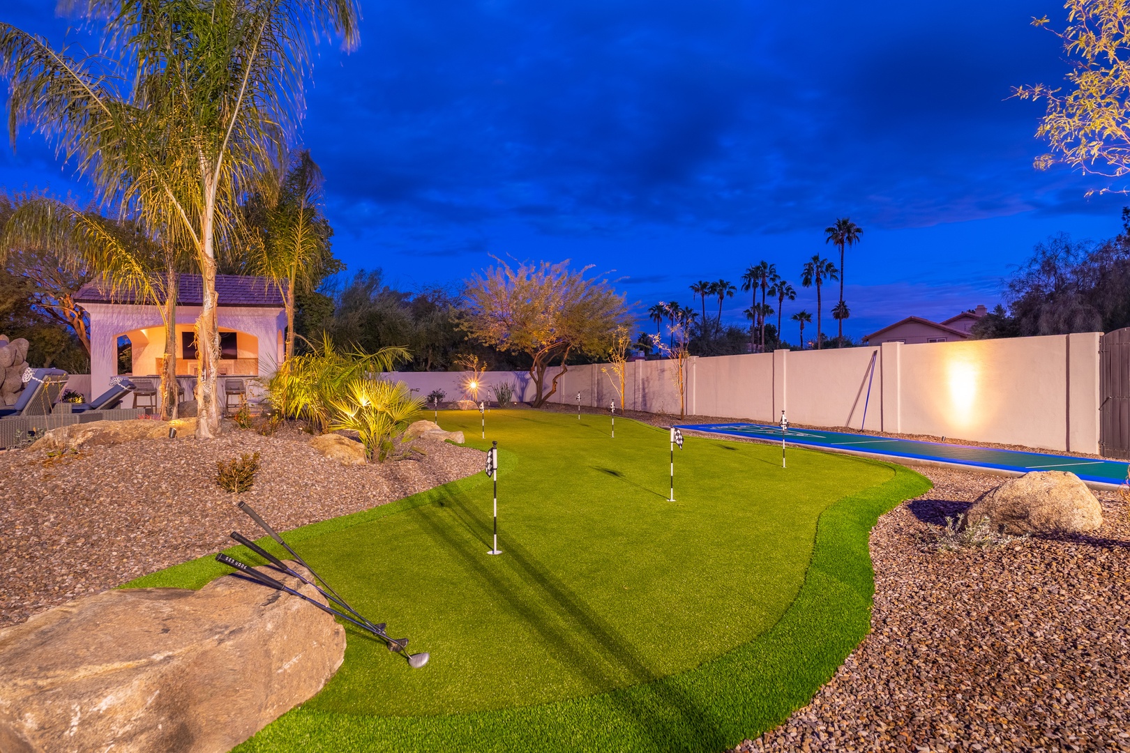 Practice your putting as twilight paints the sky in brilliant blue. This private putting green is surrounded by desert landscaping and palm trees, perfect for evening games under Arizona's stunning skies.