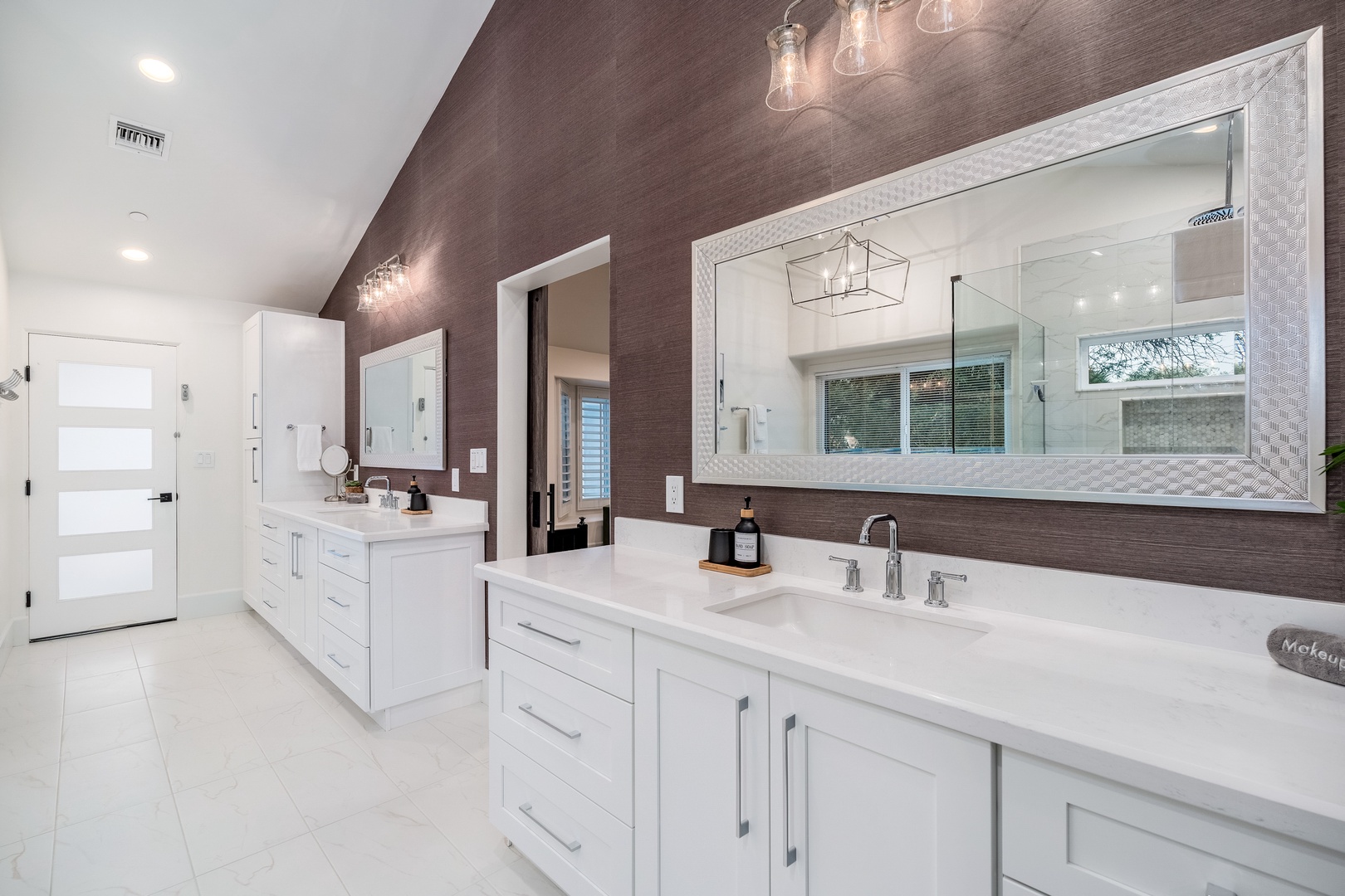 Step into your luxurious private bathroom with dual vanities, gleaming countertops, and warm textured walls—plenty of space to refresh and unwind in style.