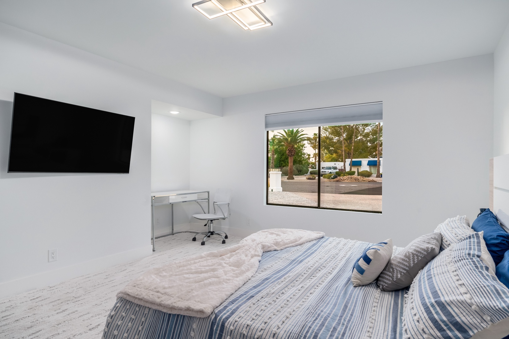 Sink into crisp linens and enjoy your favorite shows on the wall-mounted TV. Bright natural light and a sleek workspace make this your ideal retreat.