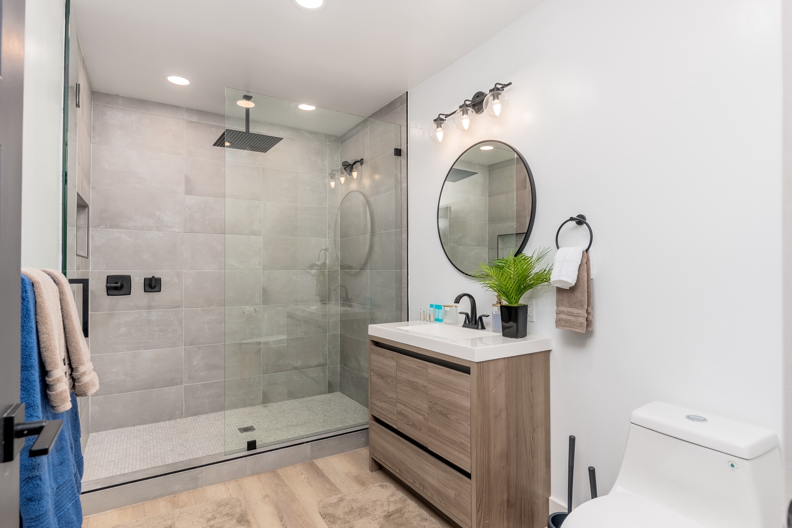 Step into your beautifully designed bathroom featuring a sleek walk-in shower, modern fixtures, and warm wood vanity—your personal retreat after exploring the area.