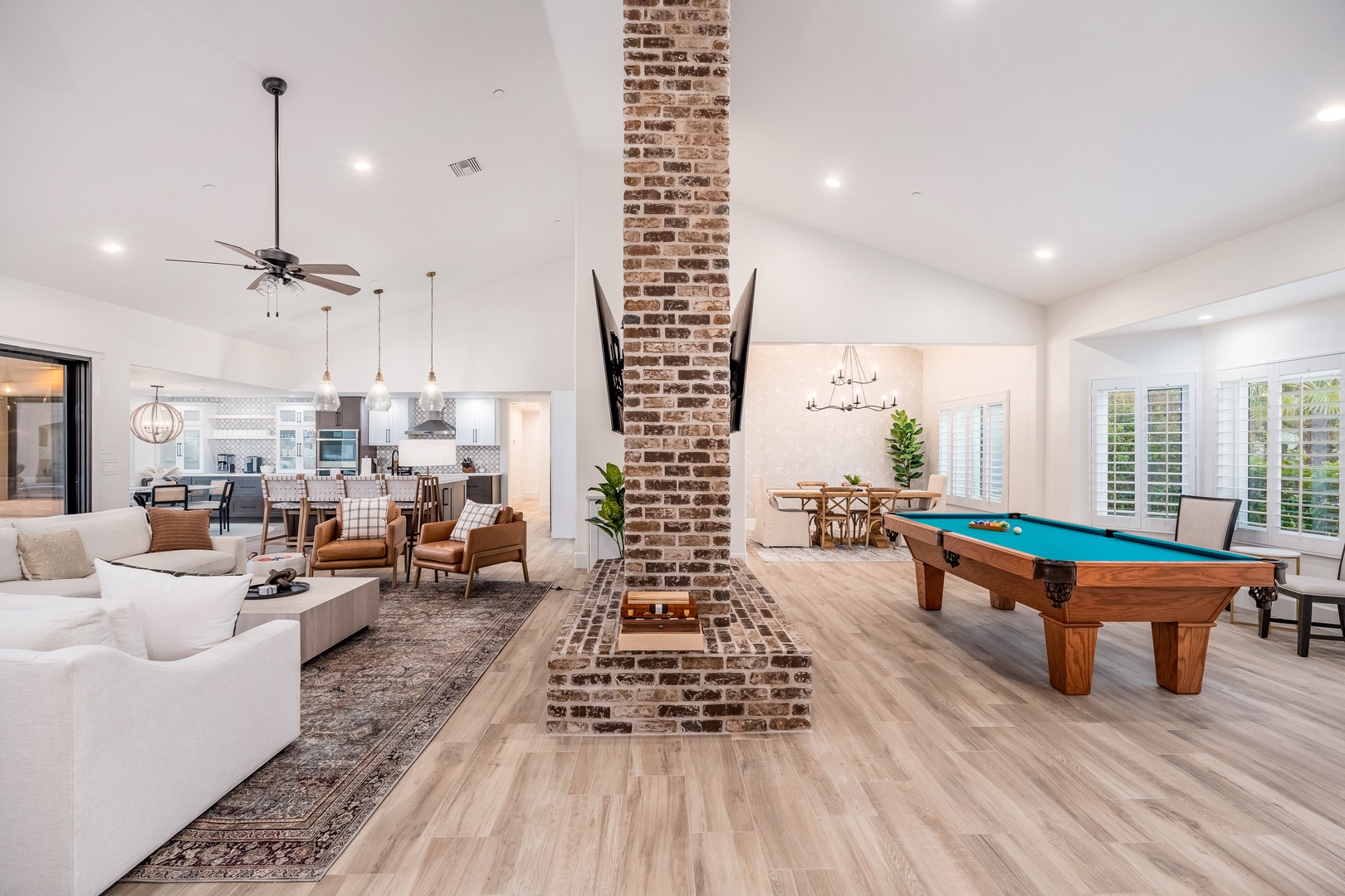 Step into your spacious open-concept retreat where exposed brick and soaring ceilings create a welcoming atmosphere. Challenge friends to billiards or unwind in the bright living area with a chef's kitchen nearby.