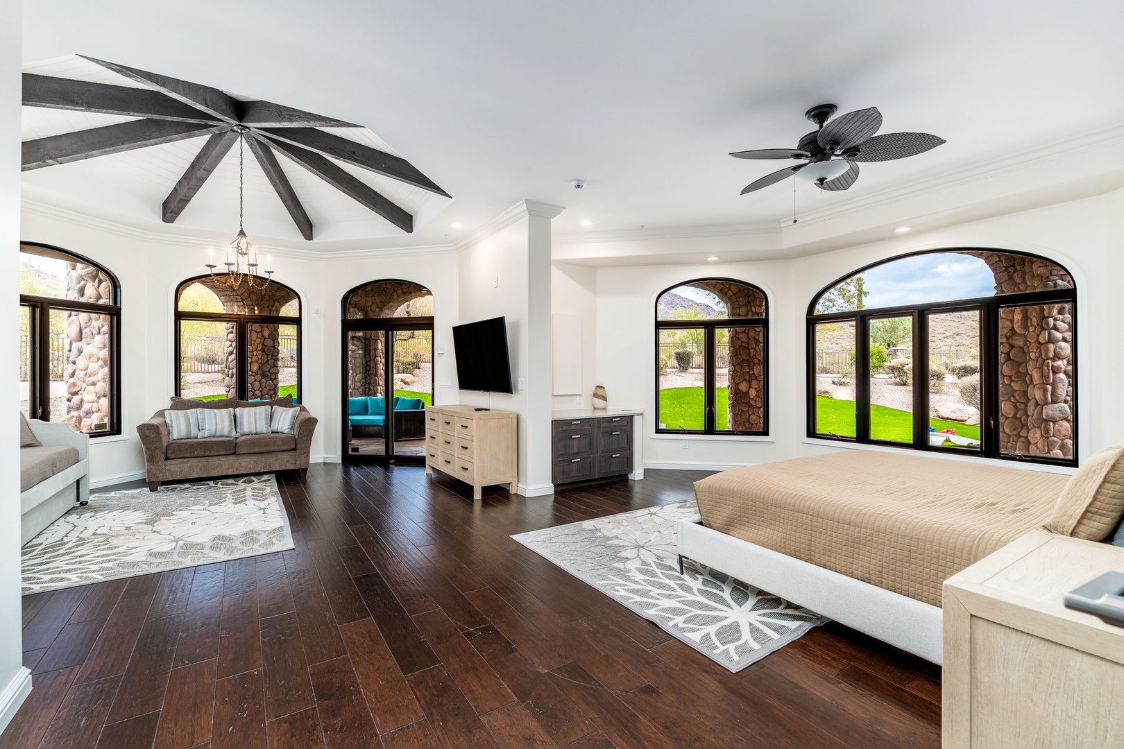 Your bright bedroom suite welcomes you with soaring ceilings, elegant arched windows, and tropical palm views framing lush green lawns. Relax in style with rich hardwood floors and direct patio access.