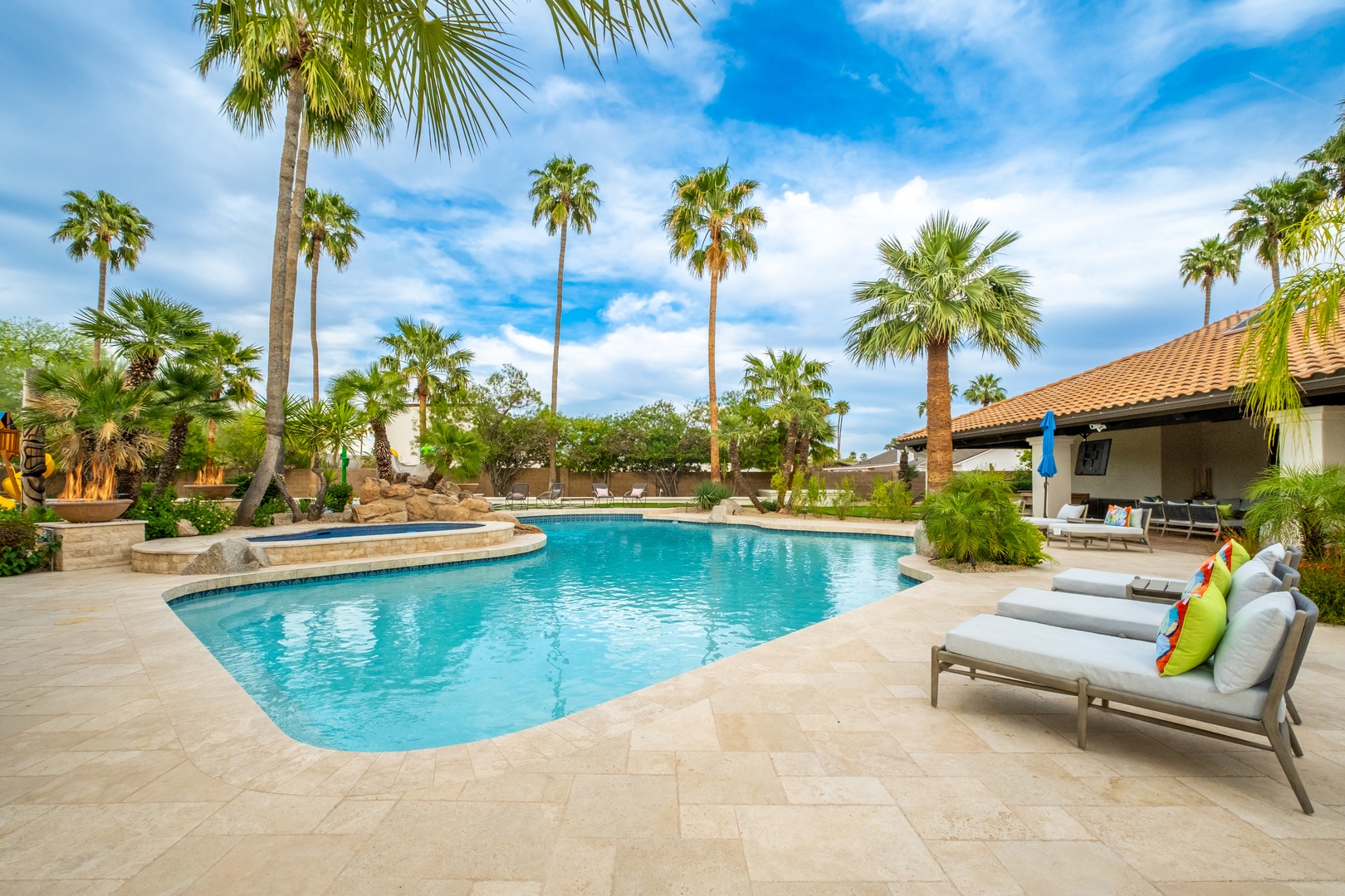 Your private oasis awaits—sparkling pool framed by swaying palms, inviting loungers for lazy afternoons, and a covered patio perfect for sun-soaked relaxation.