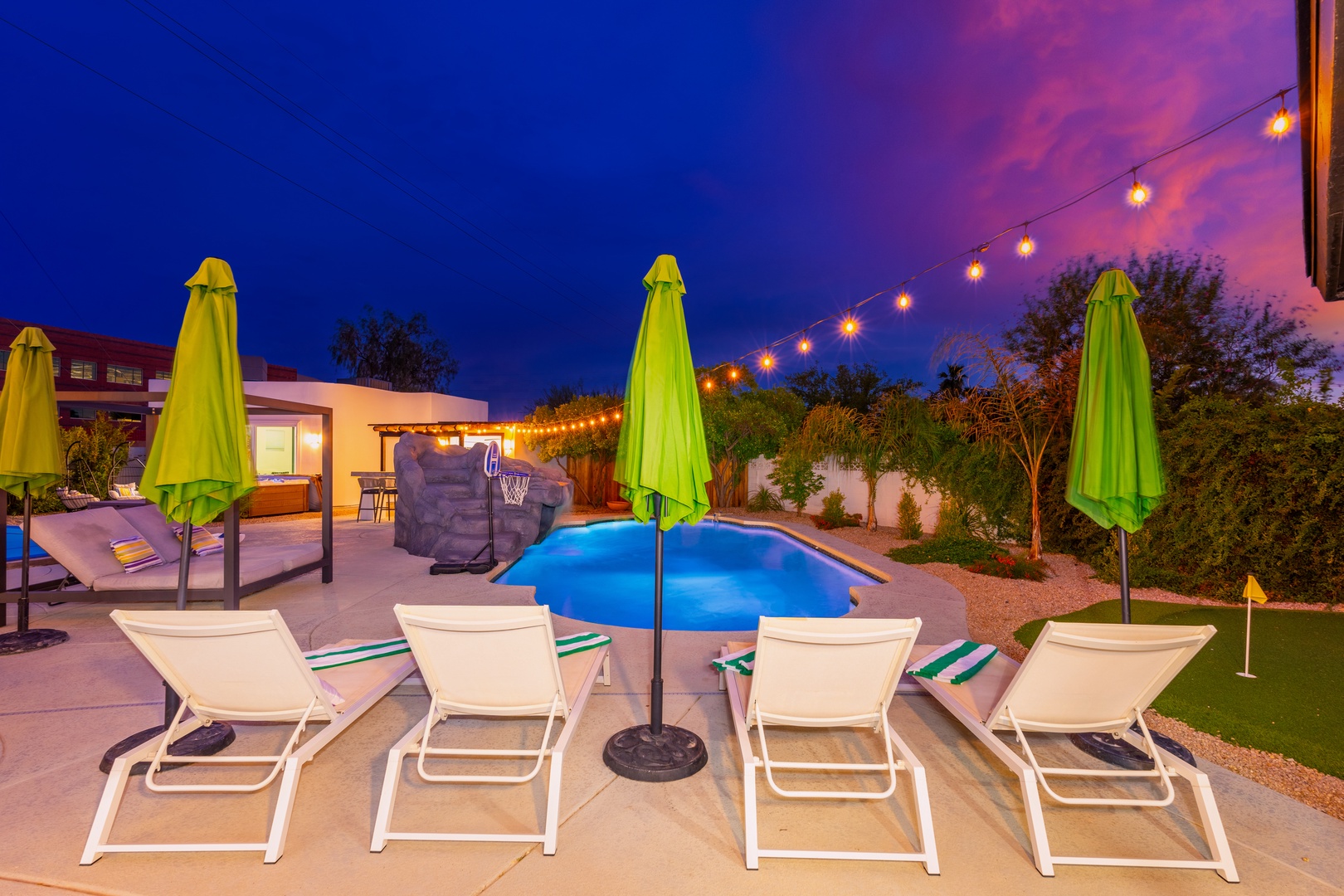 Soak in the twilight glow as string lights illuminate your private poolside retreat, perfect for evening swims and starlit relaxation under the desert sky.