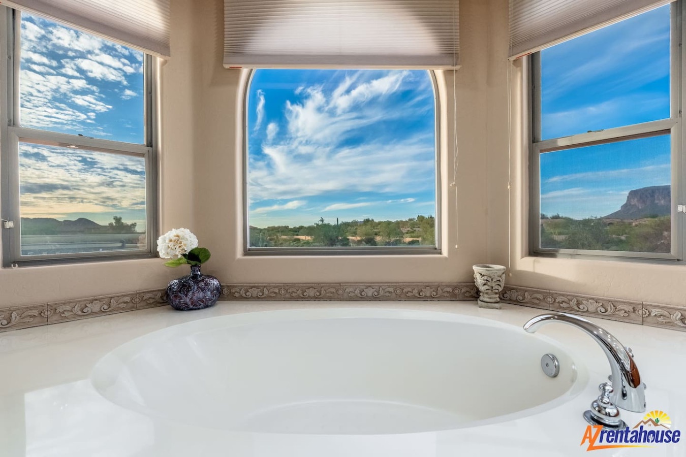 Soak in serenity as you unwind in this luxurious tub surrounded by panoramic desert mountain views through expansive windows.
