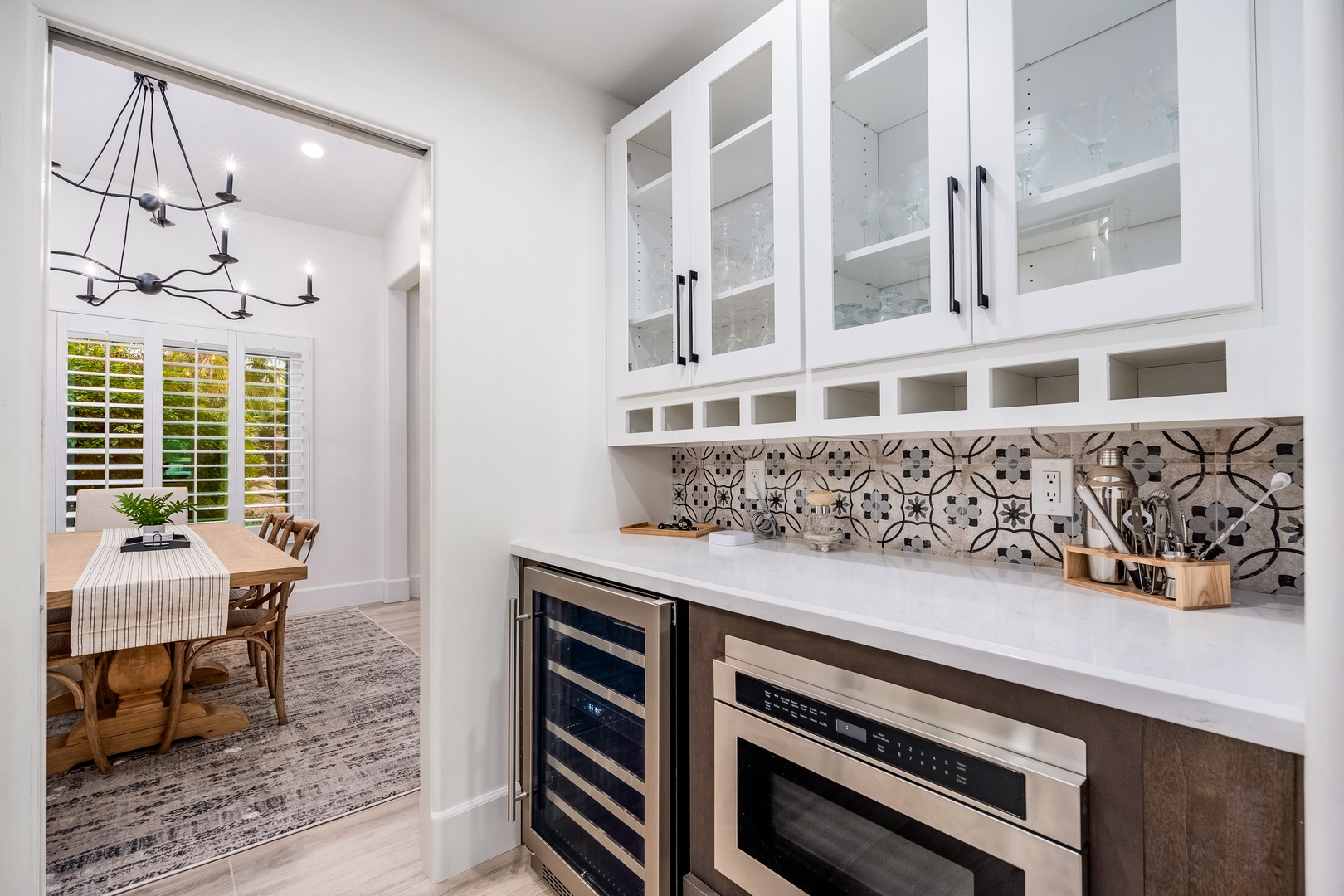 Your gourmet butler's pantry features patterned tile backsplash, built-in wine fridge, and microwave drawer—perfect for effortless entertaining and extra prep space.