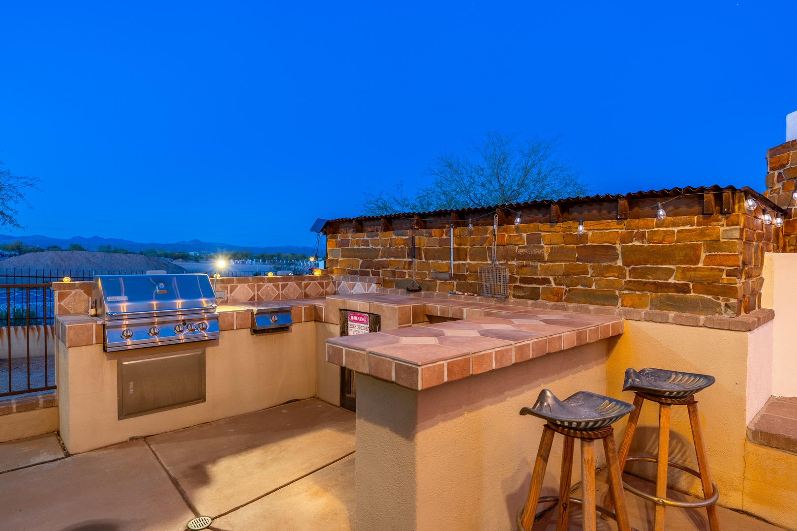 Your private outdoor kitchen awaits—grill up dinner under the stars, gather around the tiled bar with mountain and lake views, and enjoy evenings lit by soft patio lights.