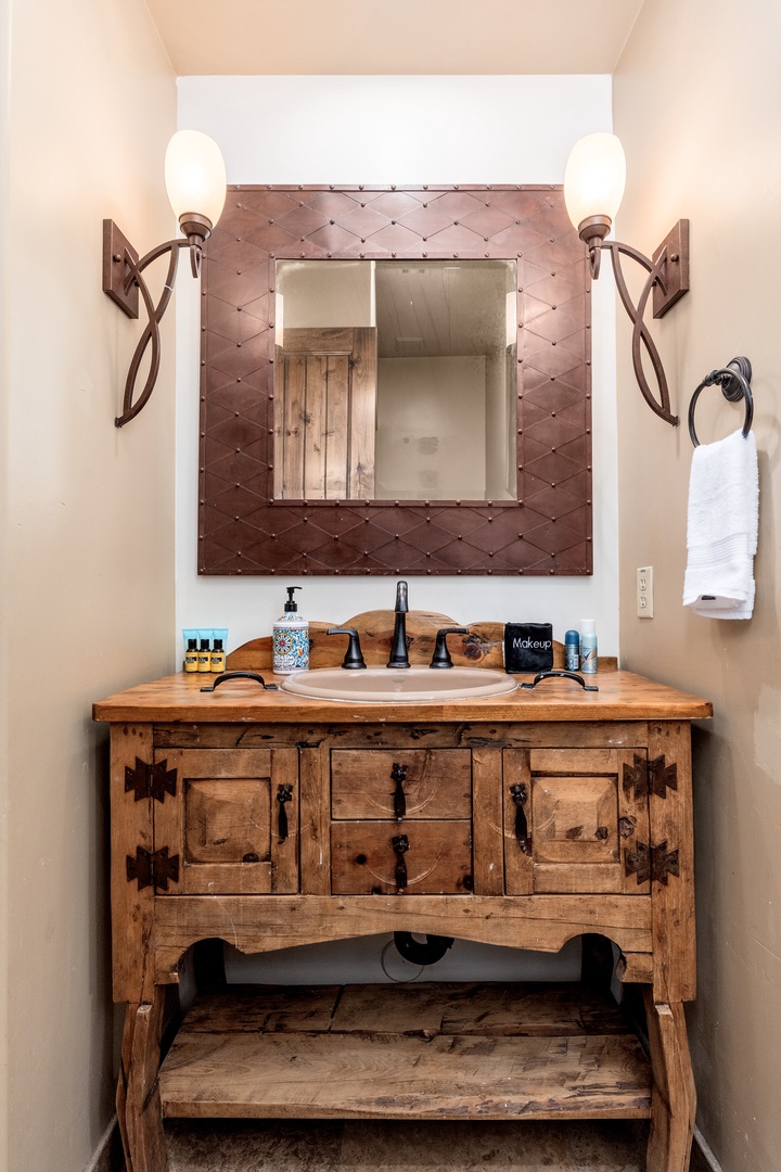 Step into your private bathroom, where rustic charm meets modern comfort. A handcrafted wood vanity anchors the space, topped with elegant fixtures and thoughtful amenities for your stay.