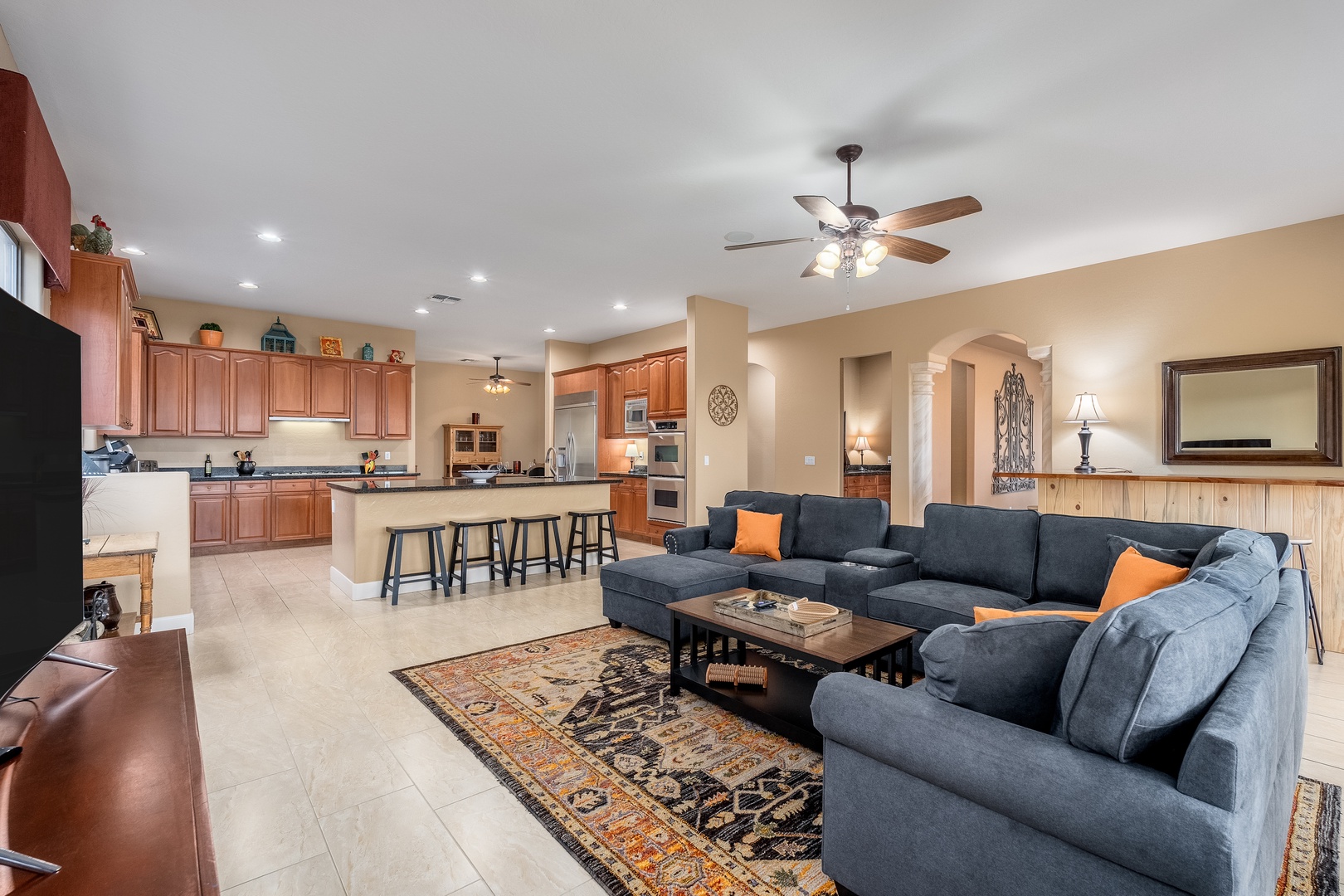 Picture yourself relaxing in this open-concept living space, where a plush sectional sofa invites you to unwind while staying connected to the fully equipped kitchen—perfect for group gatherings and quality time together.