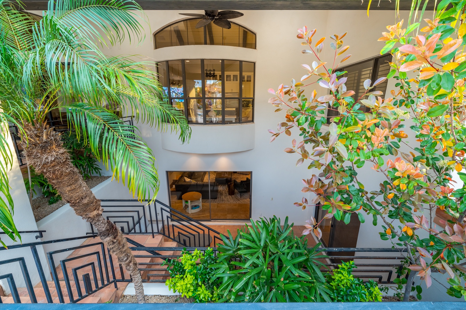 Tropical plantings and modern architectural details frame the property's elegant multi-level facade and outdoor spaces.