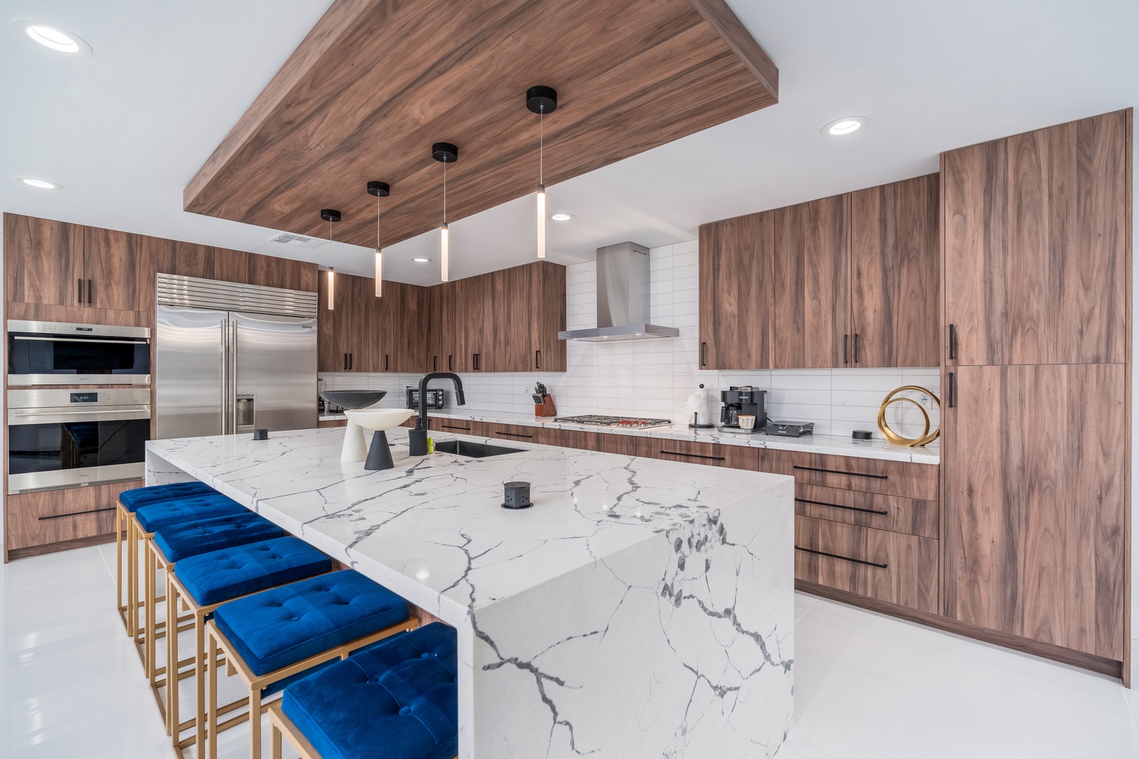 Modern gourmet kitchen featuring sleek marble island with seating, premium stainless appliances, and warm walnut cabinetry—your culinary haven awaits.