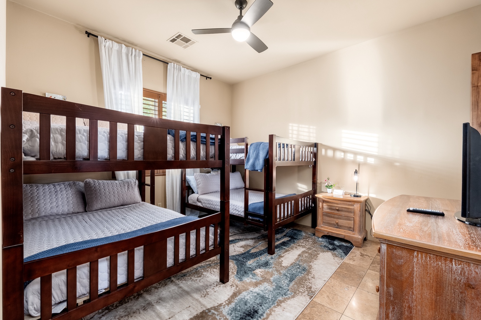 You'll love this thoughtfully designed sleeping space with two bunk beds, perfect for families or groups. The modern ceiling fan keeps the room comfortable, while the cozy bedding and natural light create a welcoming retreat for restful nights.