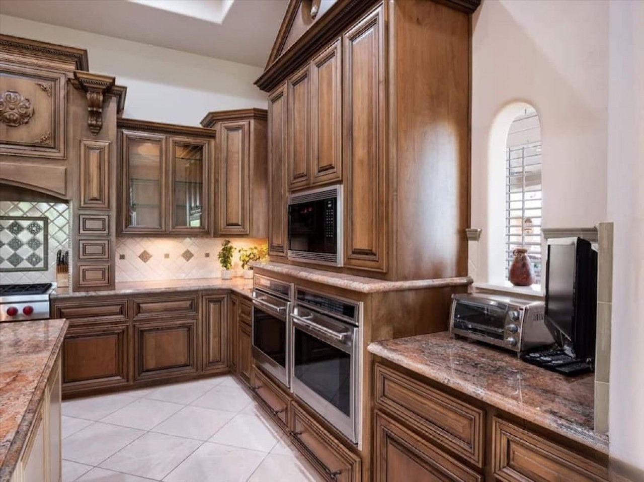 You'll love crafting meals in this elegant gourmet kitchen, featuring rich wood cabinetry, granite countertops, dual ovens, and modern appliances—perfectly equipped for your culinary adventures.