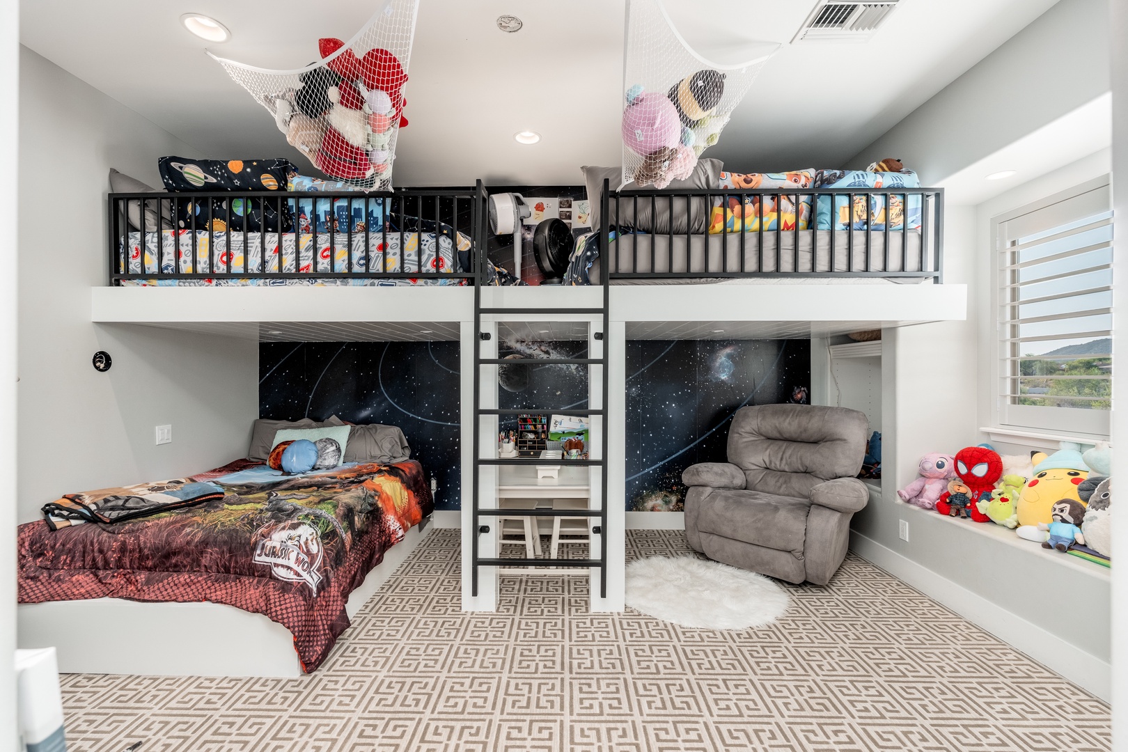 Your kids will love this cosmic-themed bunk room, where space adventures come alive with galaxy murals, cozy sleeping nooks, and plenty of play space under the lofted beds.