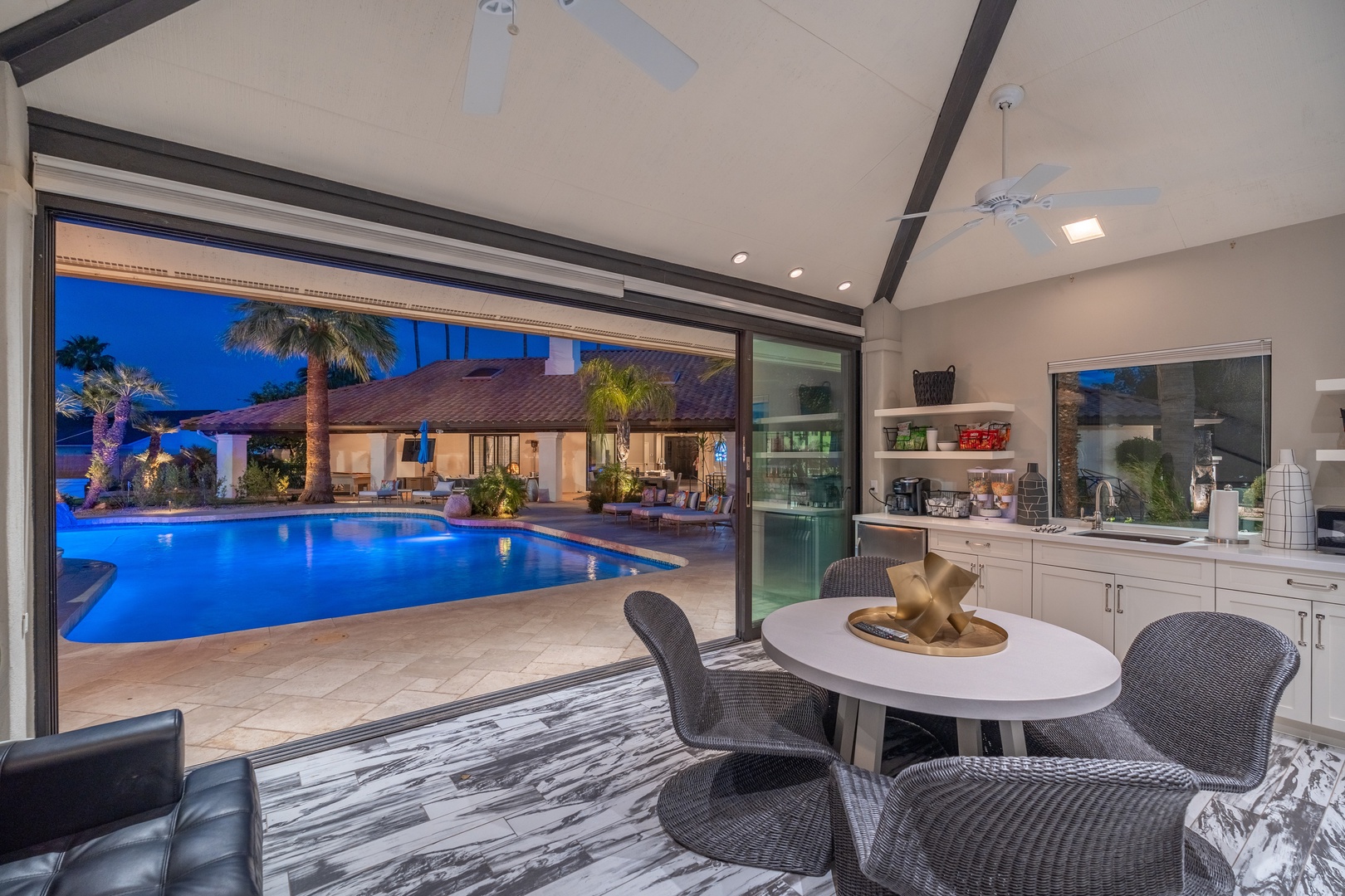 Dine with a view—your kitchen opens seamlessly to a glowing pool and serene outdoor living space, perfect for sunset dinners and tropical evenings.