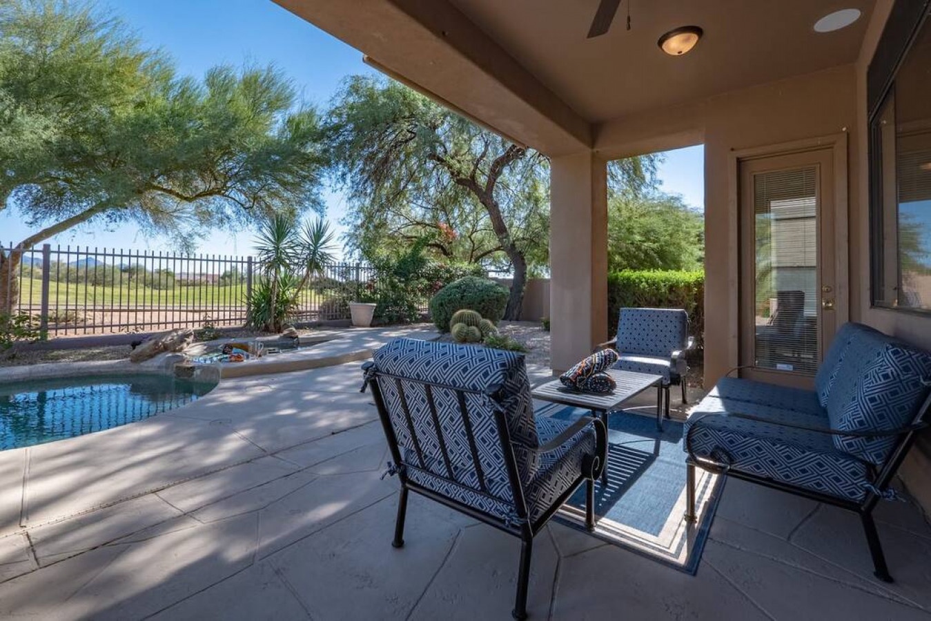 Relax in your private poolside oasis with comfortable seating and desert views through mature trees.