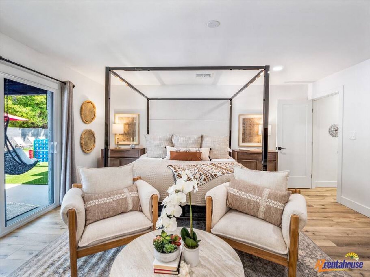 Retreat to your elegant master suite featuring a striking canopy bed and cozy seating area perfect for morning coffee.