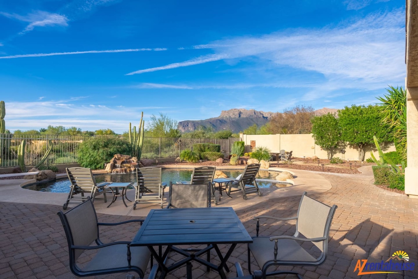 Desert mountain views frame this private pool area with paved patio and desert landscaping, creating a serene southwestern atmosphere.