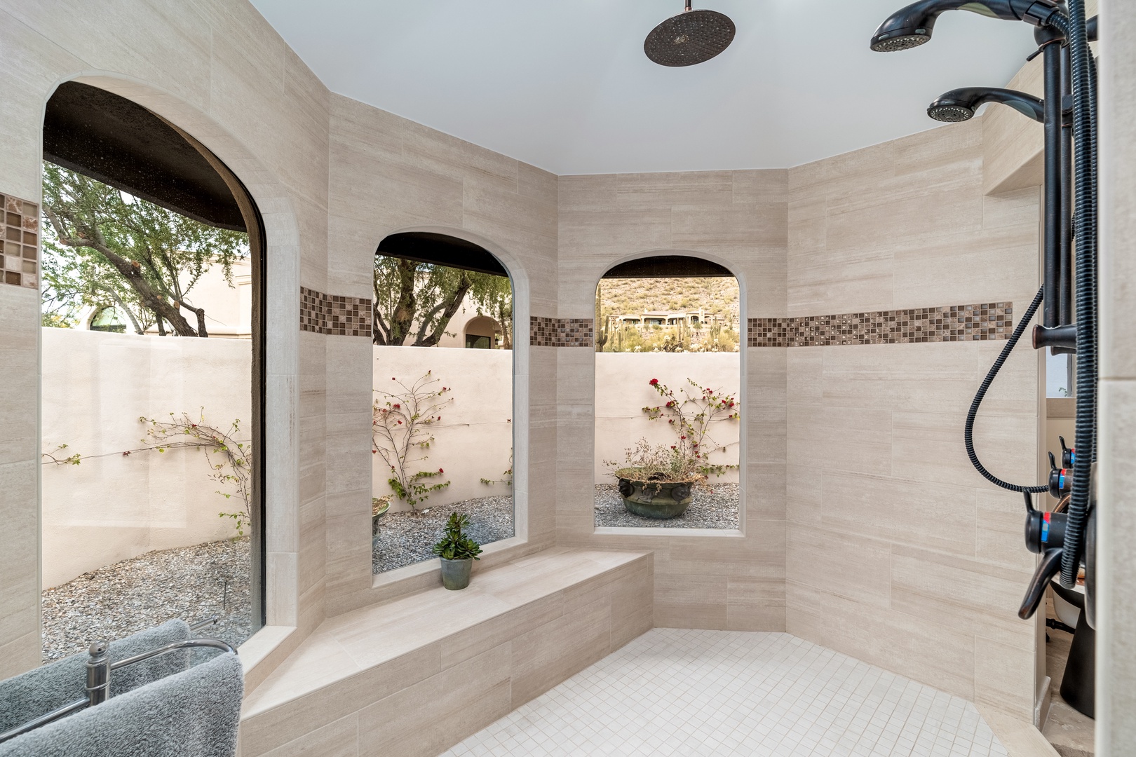 Step into your private spa-like shower, where natural light pours through arched windows framing a tranquil garden. Multiple showerheads promise a truly indulgent experience.