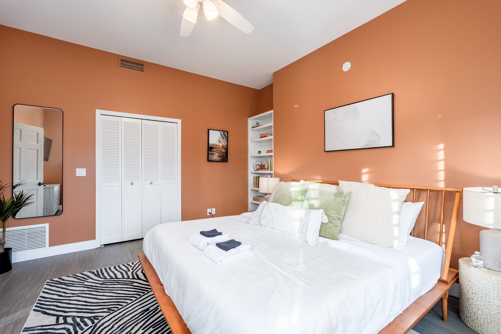 Settle into crisp white linens against warm terracotta walls. Your serene retreat features modern comfort with a ceiling fan, ample storage, and thoughtful touches inviting restful nights.
