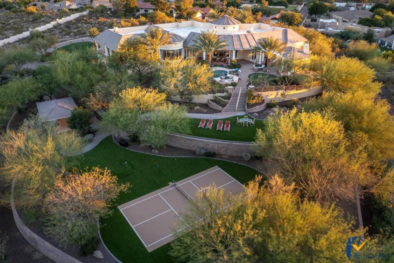 Stunning luxury estate with tennis court, swimming pool, and manicured grounds nestled in a private desert community.