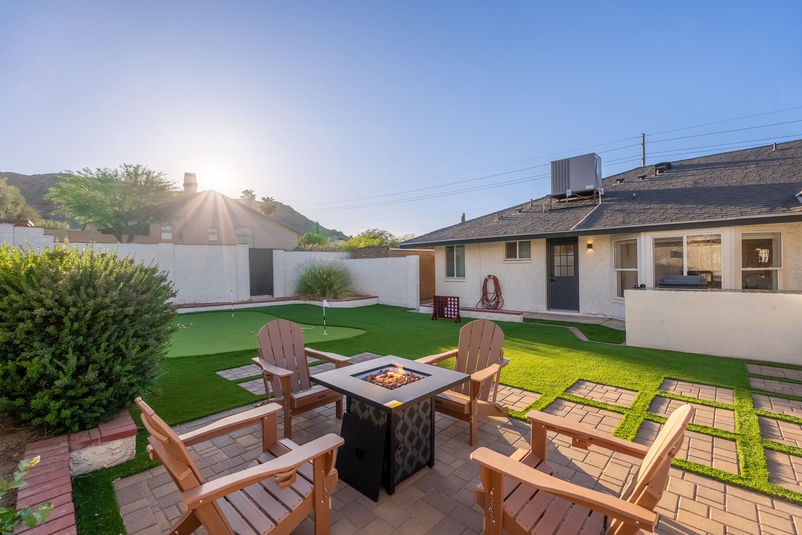 Gather around the fire pit in your private backyard oasis, perfect for evening conversations under the stars. The spacious lawn and patio seating create the ideal setting for relaxation and outdoor fun.