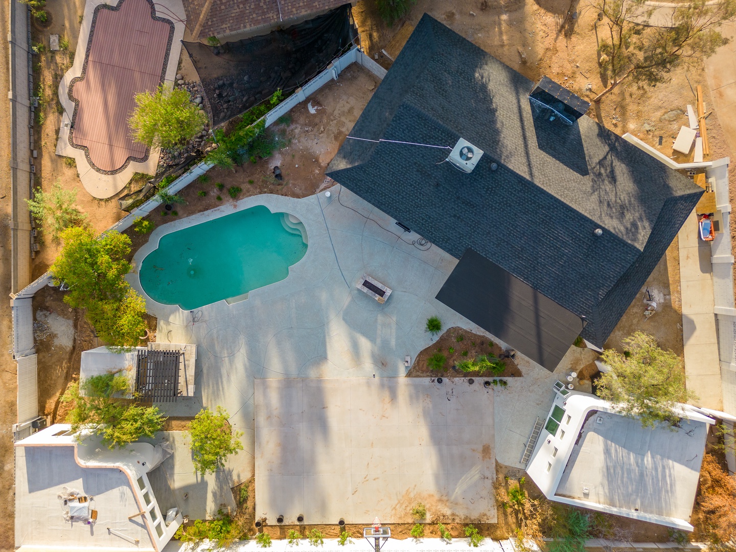 Aerial view showing the property's layout, featuring a private pool, mature landscaping, and residential architecture set in a peaceful neighborhood.
