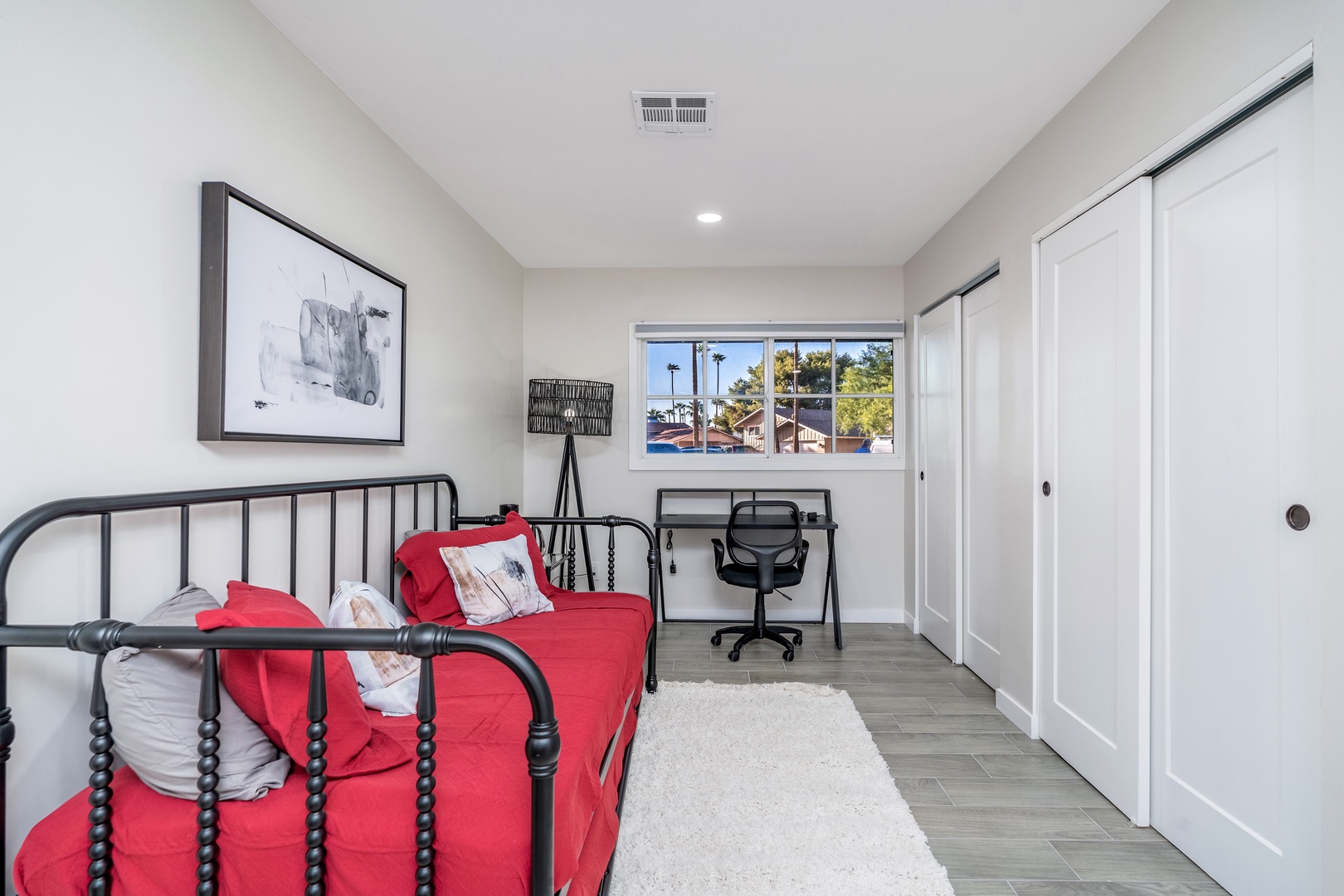 Unwind in your bright, modern bedroom with comfy bedding and a dedicated workspace. The large window invites natural light, while ample closet space keeps your belongings organized.