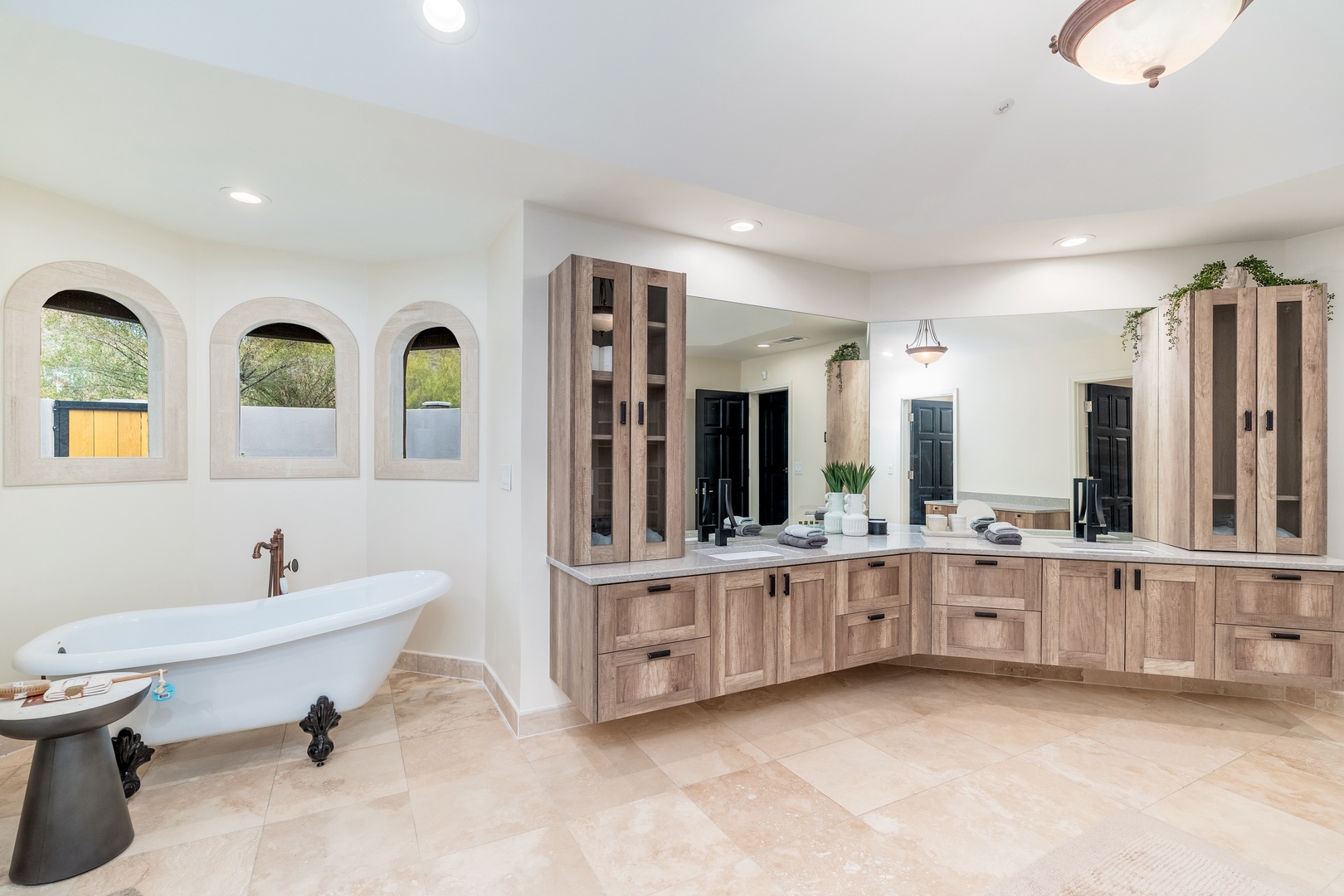 Step into your luxurious en-suite bathroom featuring a stunning freestanding soaking tub, elegant arched windows, and dual vanities with abundant storage. Unwind in style with high-end finishes and a spacious, spa-like ambiance designed for ultimate relax