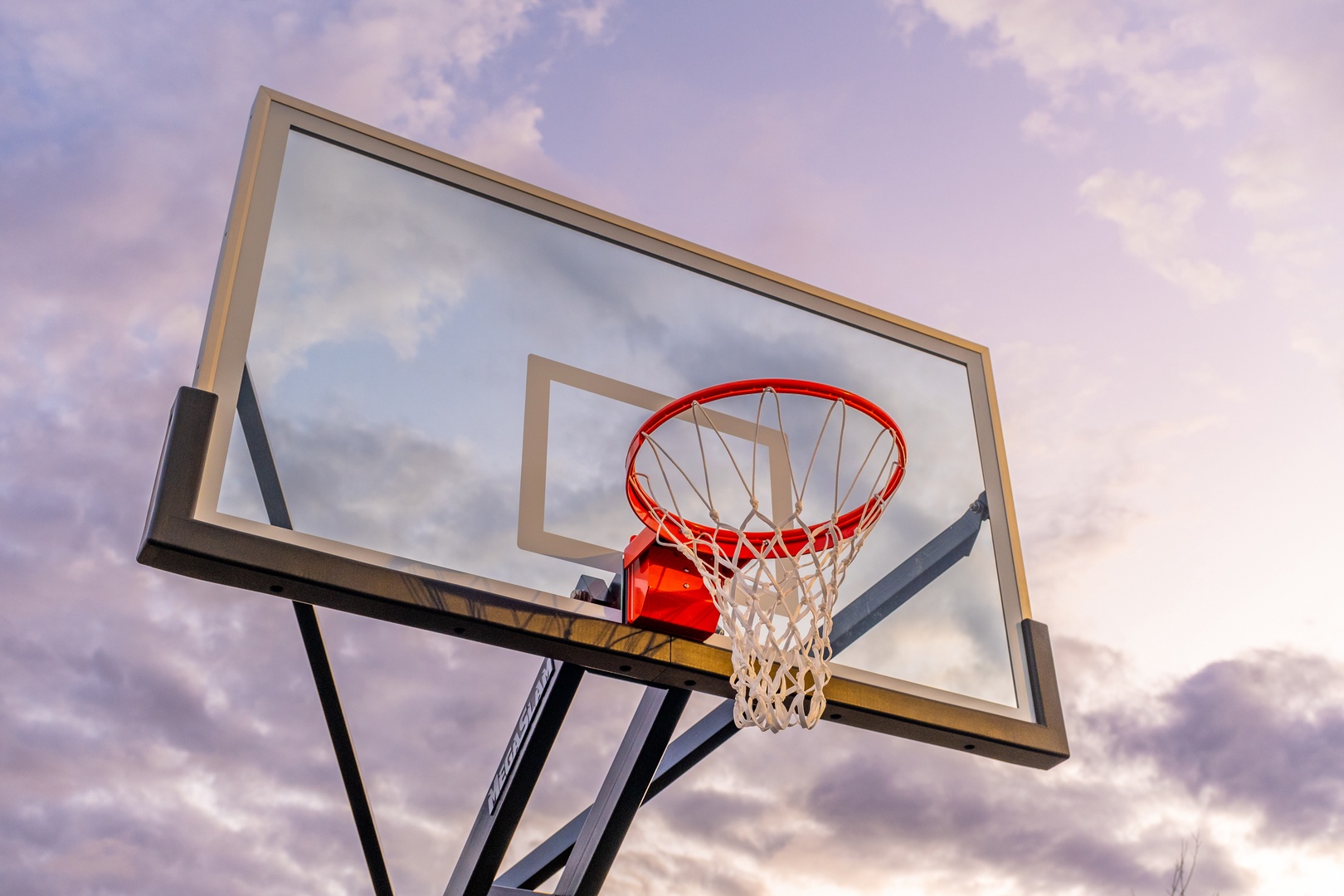 An outdoor basketball hoop stands ready for friendly games beneath soft, colorful skies—perfect for active getaways and casual competition.