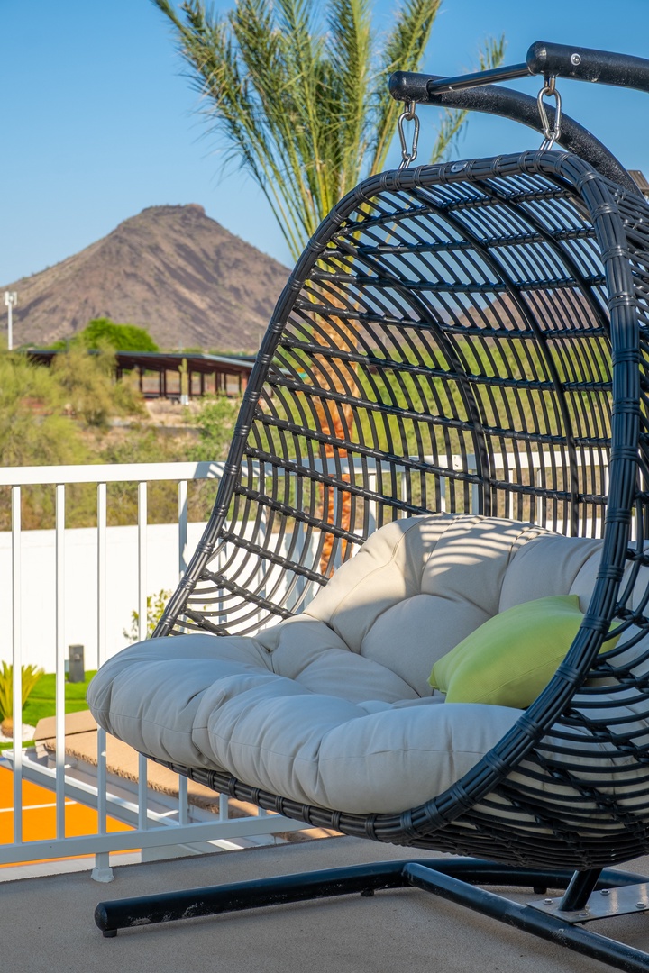 Swing into relaxation in this cozy hanging chair, your perfect perch for soaking up desert mountain views and sunny skies.