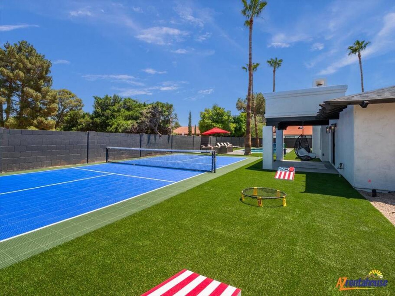 Your private backyard paradise features a regulation tennis court, lush artificial turf, and covered patio for endless entertainment.