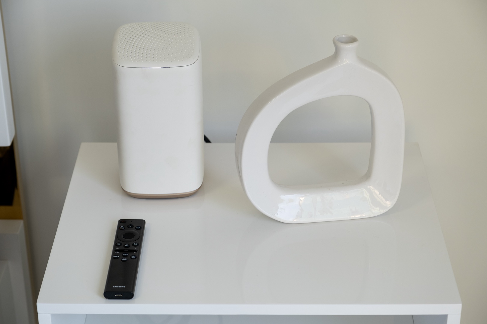 Modern nightstand with sleek accent pieces and remote control, blending clean design with functional comfort for your stay.