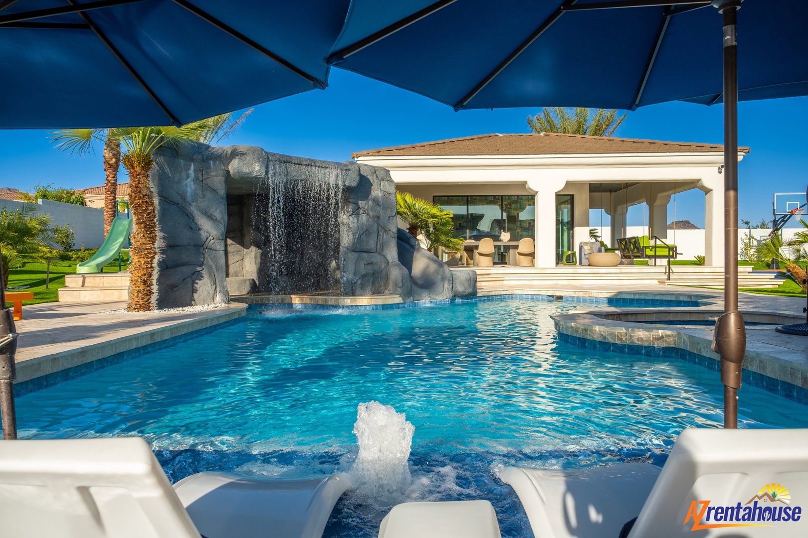 Dive into your private oasis featuring crystal-clear waters, cascading waterfall, and poolside lounging under desert palms.