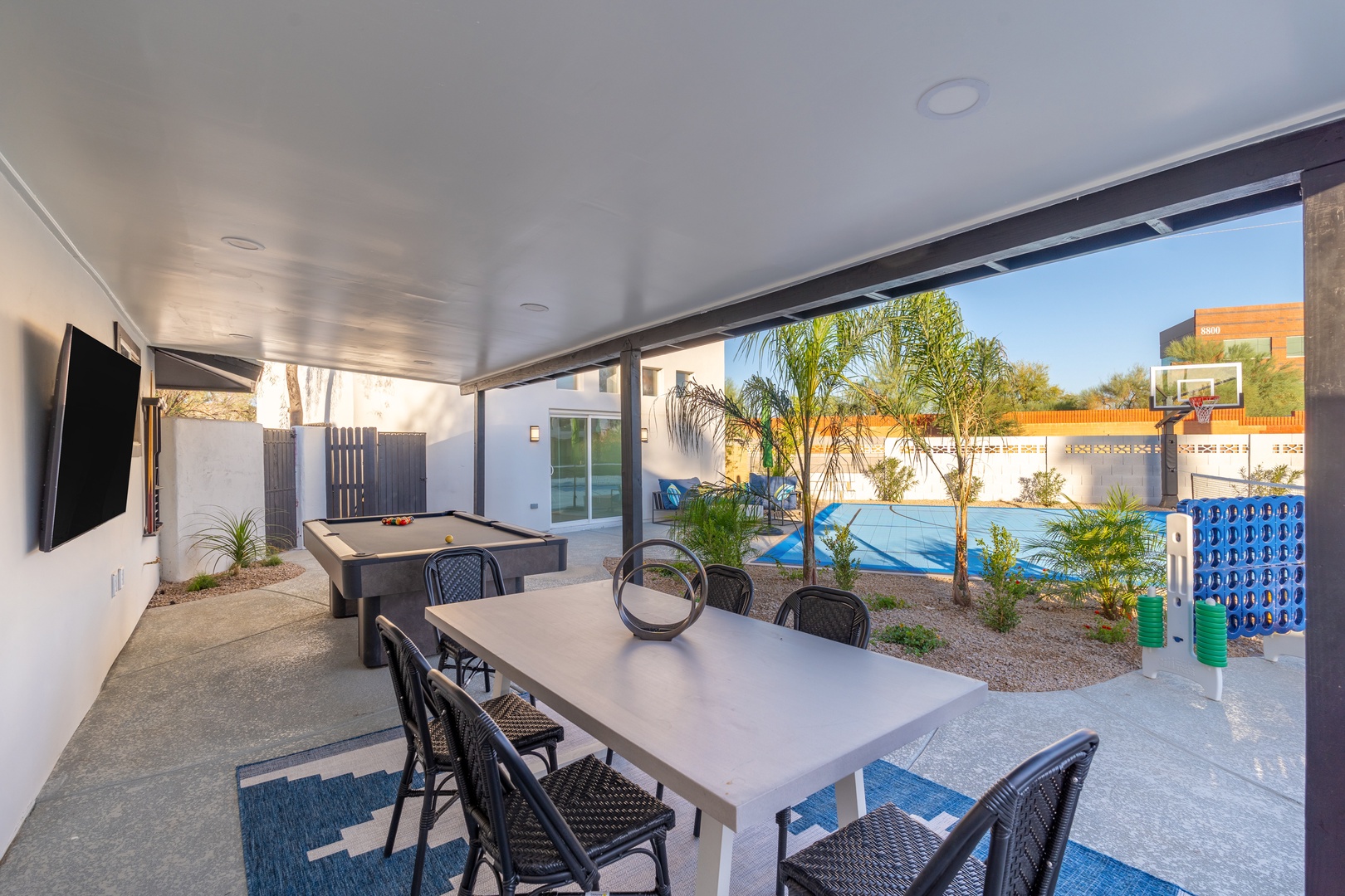 Enjoy sunny afternoons under your private covered patio with pool table and dining for eight, overlooking a sparkling blue pool and lush tropical palms. Perfect for entertaining or simply unwinding in style.