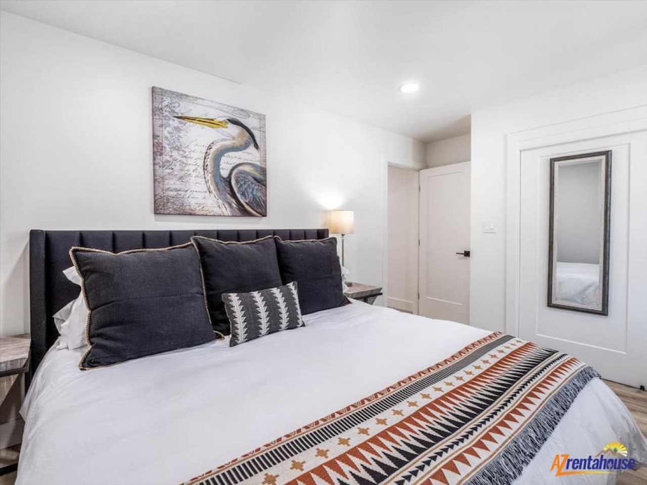 Sink into this plush king bed with its striking tufted headboard, where thoughtful decor and soft lighting create your perfect retreat.