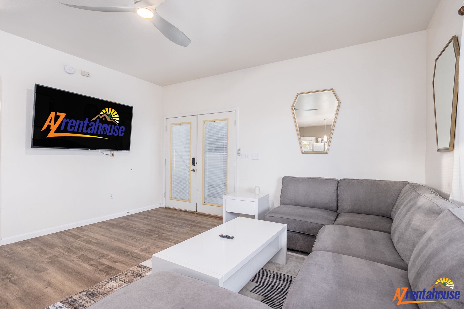 Unwind in your bright, modern living room with plush seating, sleek décor, and a large TV—perfect for relaxing after exploring the area.
