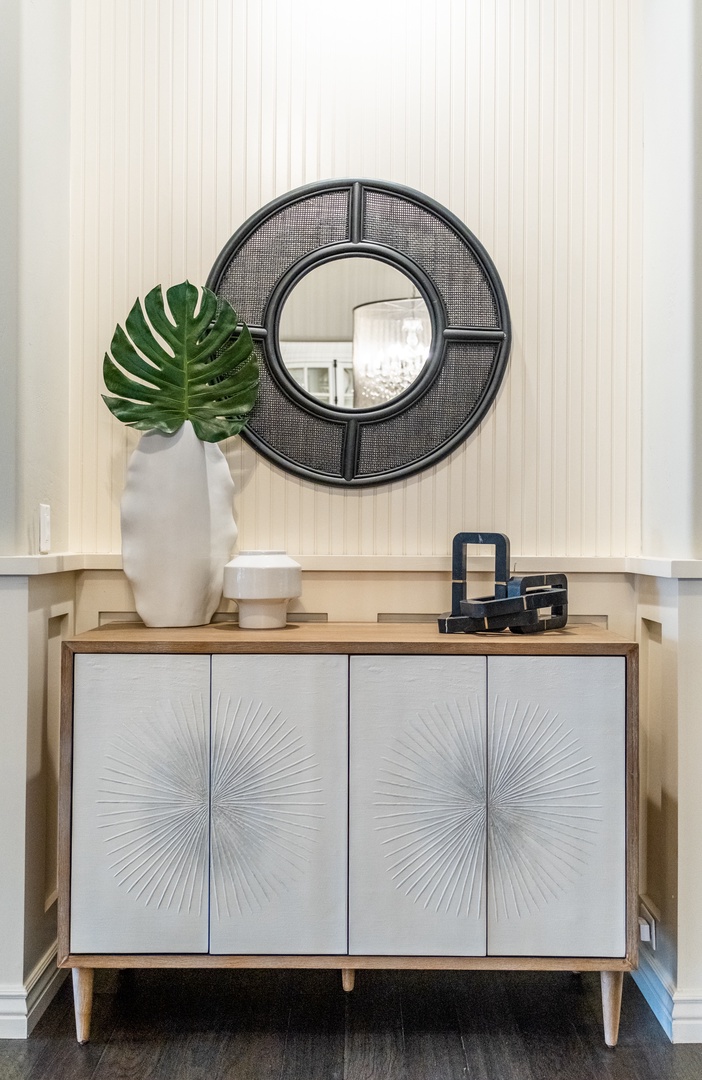 A sleek console with geometric details and fresh greenery welcomes you at the entryway, setting a stylish and inviting tone from the moment you arrive.