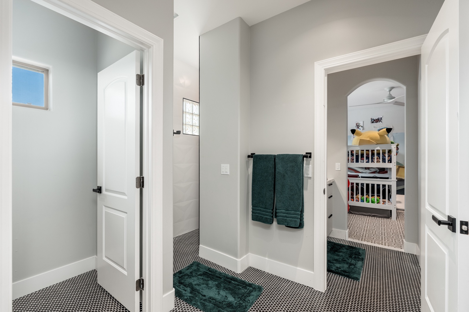 Freshly styled bathroom connects to a cheerful bunk room—plush towels, modern tile, and thoughtful details ready for your family's stay.