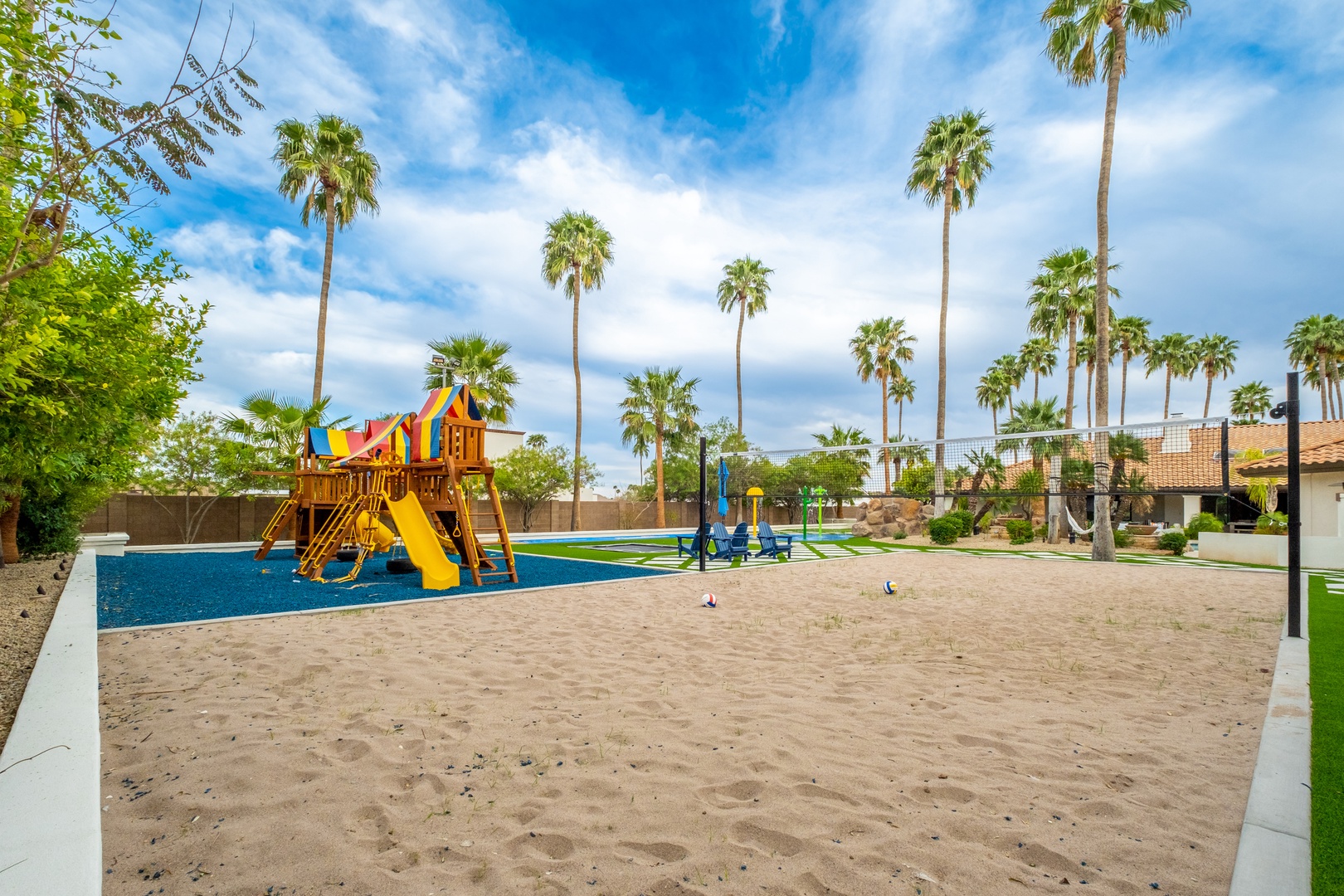 Kids can burn off energy on the colorful play structure, sandy play area, and sports court under swaying palms.